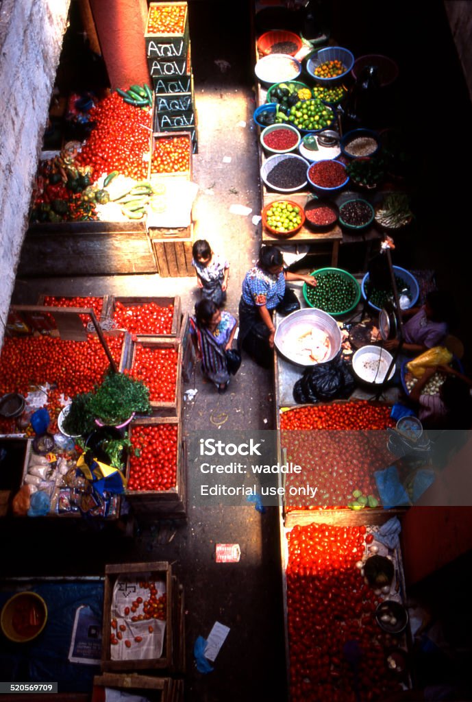 Guatemalan rural market scene San Pedro la Laguna (Atitlan), Guatemala – August 20, 2001: Traditional dressed women shopping at the local covered food market. Abundance Stock Photo