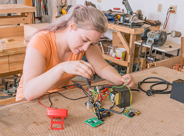 istock Young adult female working on assembling circuit components 520583428