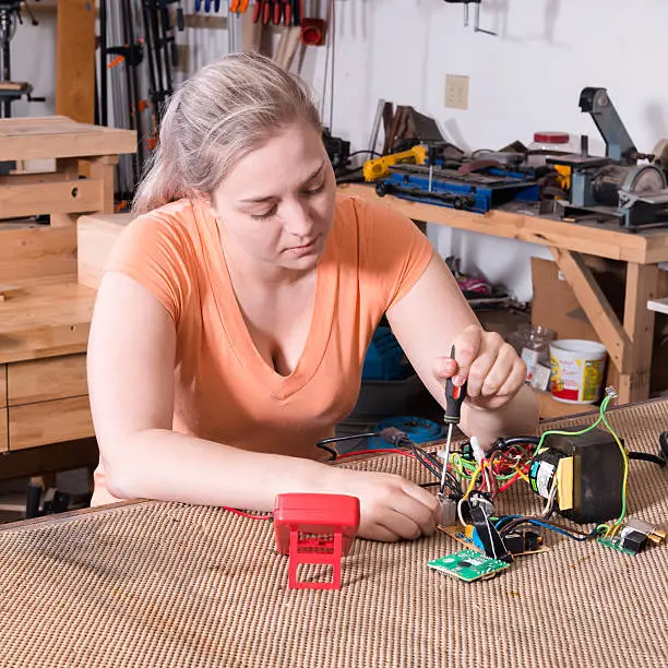Young adult female working on assembling circuit components
