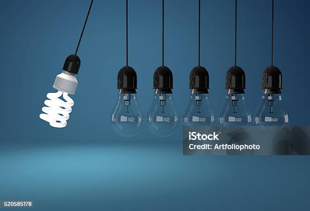 Energy Saving And Incandescent Bulb In Perpetual Motion Over Blu Stock Photo - Download Image Now