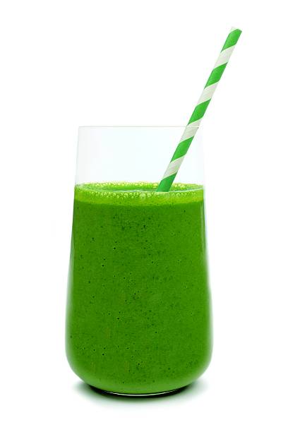 istock Green smoothie in a glass with paper straw isolated 520585232