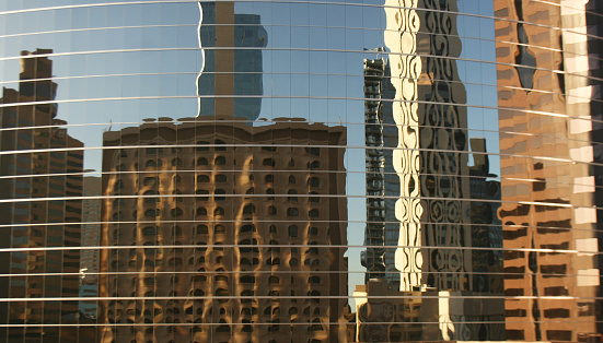 Background image of reflections of modern office buildings in windows of another higher building