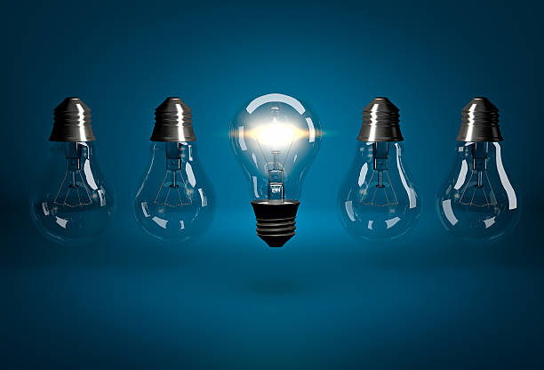 istock Glowing bulb in row of dead bulbs hanging upside down 520586874
