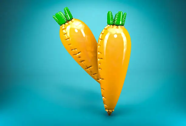 Two inflatable carrots on blue background. Concept of artificially modified vegetables.