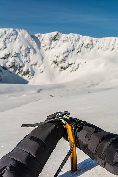 istock Mittens clipped carabiner on a yellow ice axe. 520587960