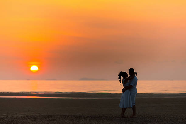 istock bride and groom on a tropical beach with the sunset 520590464