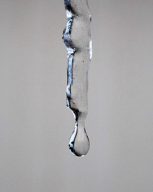 istock Single water droplet hangs on to its icicle 520590556