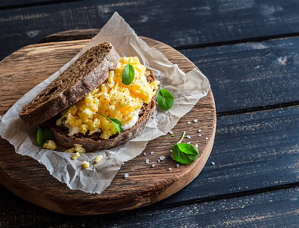 un sándwich de huevo salió corriendo sobre fondo de madera rústica - pan de centeno fotografías e imágenes de stock