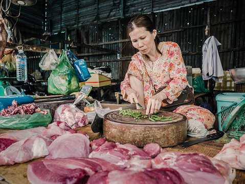 Siem reap, Сambodia - February 25, 2016: People selling fresh food at Phsar Leu Thom Thmey market in Siem Reap Cambodia. This is one of the largest public markets of the city. Hundreds of market stalls inside the building and outside of it sell their goods everyday to local residents.