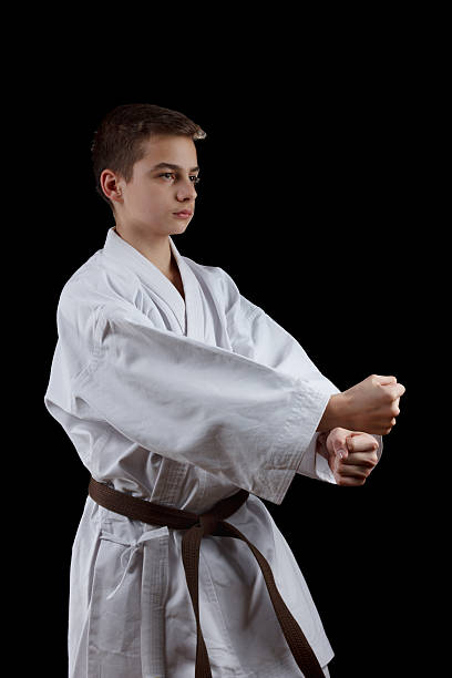 istock Karate Fighter in white Kimono Isolated on Black 520593390