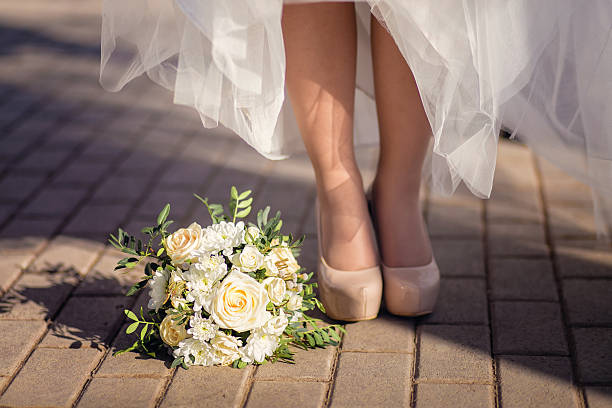 istock Bride's shoes and bouquet on the grass 520593446