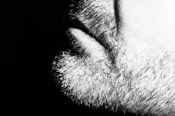 Close-up of mature man resting chin on palm, low key, black and white