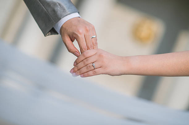istock close up bride groom holding hand with sunset (selective focus) 520593668