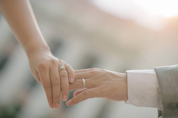 istock close up bride groom holding hand with sunset (selective focus) 520593796