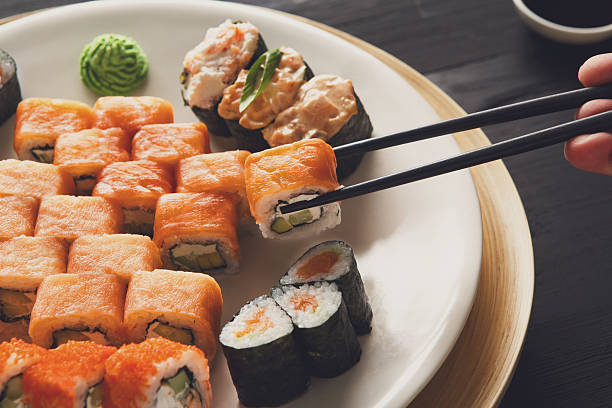 istock Eating sushi rolls at japanese food restaurant 520593840