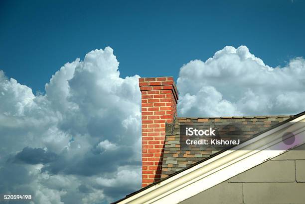 Part Of Tiled Roof With Brick Chimney Against Clouds Stock Photo - Download Image Now