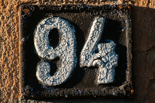 Old retro weathered cast iron plate with number 94