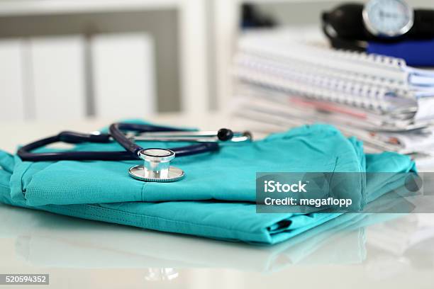 Medical Stethoscope Lying On Green Doctor Uniform Closeup Stock Photo - Download Image Now