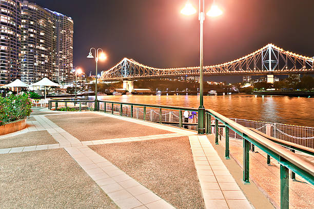 istock Waterside beside a river at night with long bridge 520594526