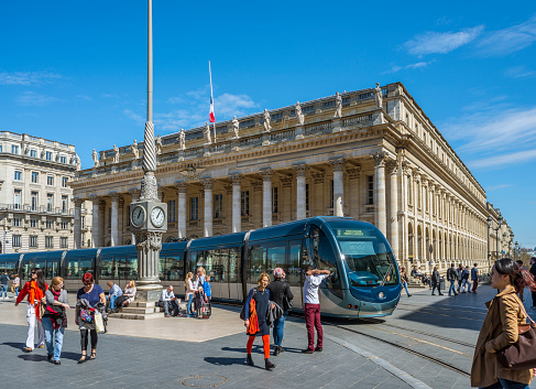 Bordeaux, France - March 26, 2016. Tram rolling in front of Grand Theatre de Bordeaux at sunny day. The theatre is home to the Opera National de Bordeaux and the Ballet National de Bordeaux. Bordeaux, Aquitaine.
