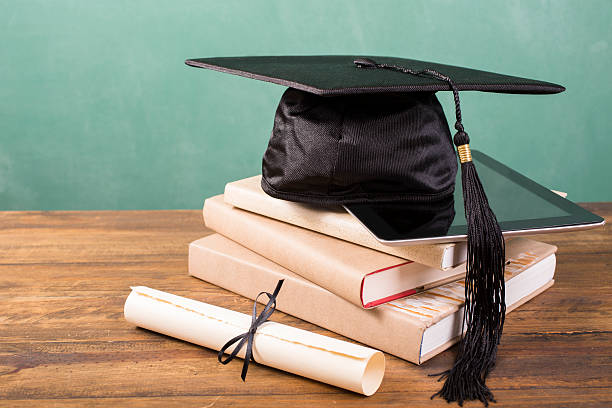 istock Graduation!  Cap, motarboard, diploma, digital tablet. Books on desk. Education. 520608390