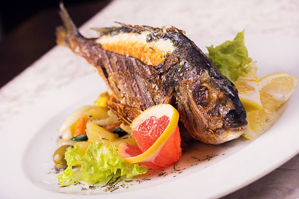 istock Grilled Fish on a Plate with Fruit and Vegetables 520609214