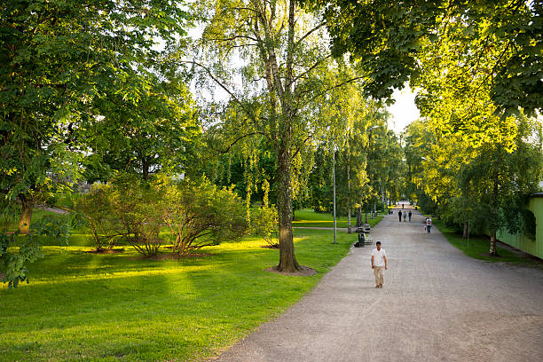 Helsinki, Finland - July 5, 2015: People walk on a summer evening in Kaisaniemi park, located in the center of Helsinki in the region of Kluuvi.