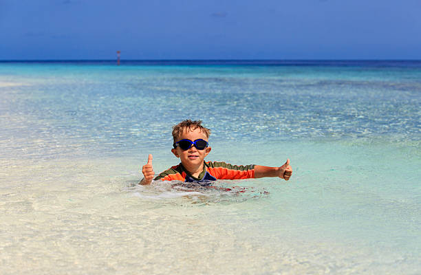 istock happy little boy swimming at tropical beach 520609498