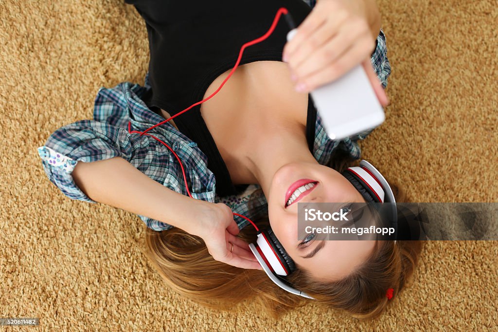 Wunderschöne blondine lächelnde Frau liegend auf dem Teppich in hea Etage - Lizenzfrei Buch Stock-Foto