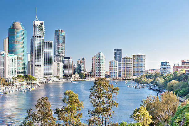 istock Huge city with tall buildings among trees and river 520611562