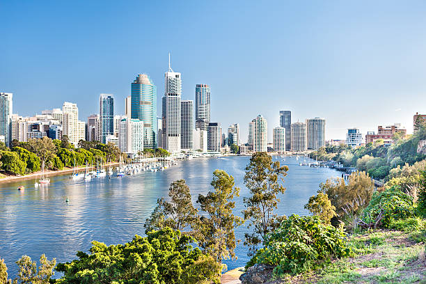 Blue water river surrounded by trees beside a modern city Blue water river surrounded by trees beside a modern cityscape including lots of tall buildings  under blue sky called Brisbane City, Queensland, Australia. brisbane photos stock pictures, royalty-free photos & images