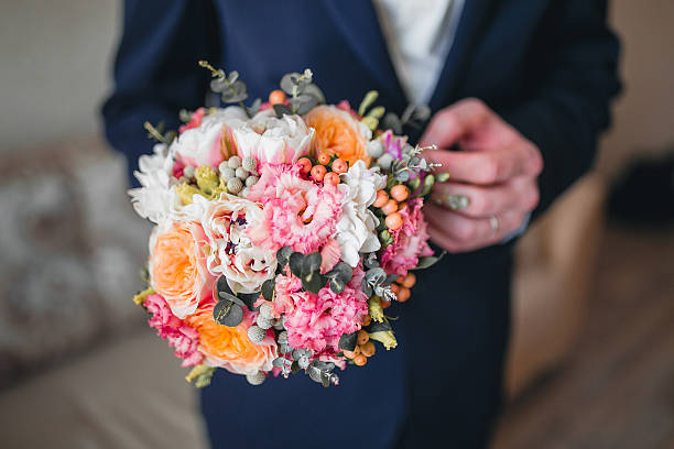 istock groom hold wedding bouquet 520612176