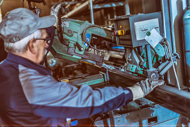 istock Senior worker operating a steel-cutting machine 520614306
