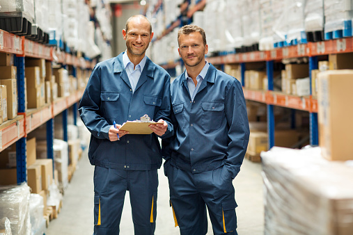 Portrait of confident workers standing in distribution warehouse