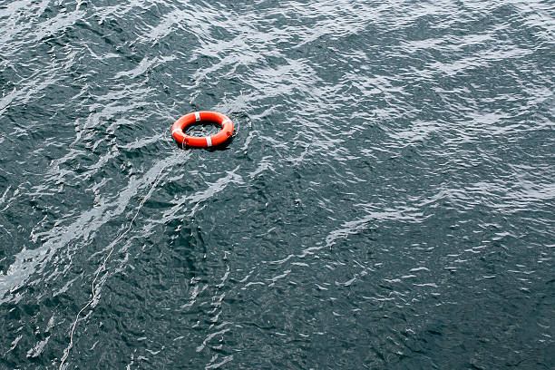 istock orange lifebuoy thrown to assist floats on water 520616948