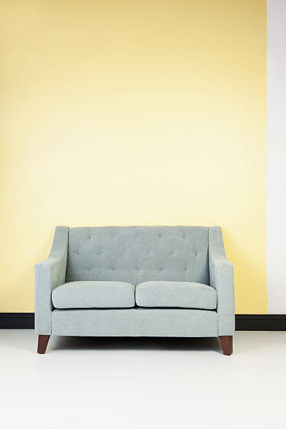Modern Seafoam Green Couch Against a Pastel Yellow Wall