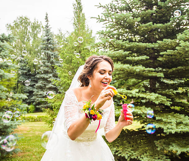 istock Young bride blowering soap-bubble and joy smile 520618564