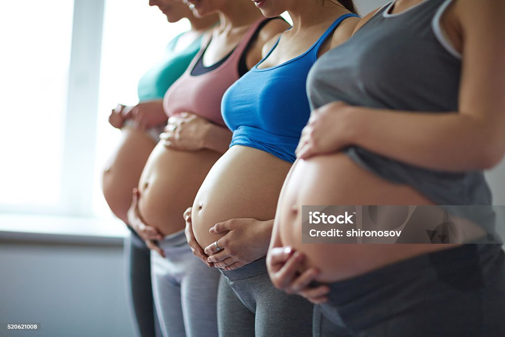 Row of pregnant women Young pregnant women standing in row Pregnant Stock Photo