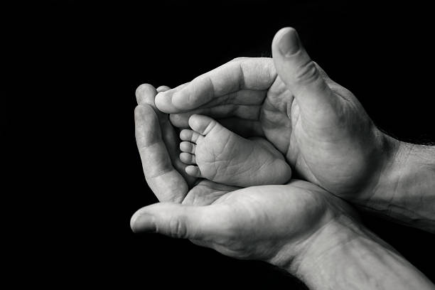 istock Newborn's Foot in Father's Hands 520621125