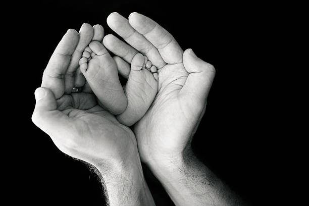 istock Newborn's Feet in Father's Hands 520621127