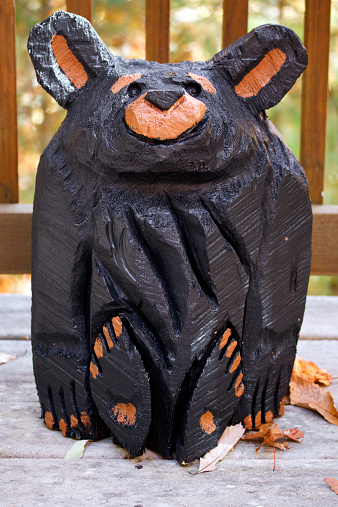 A painted wooden bear carved from a log.