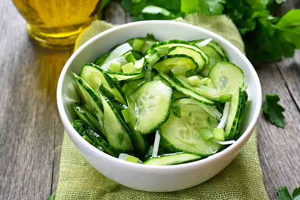 Cucumber salad in white bowl, close up view