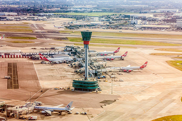 Air Traffic Control Tower / Visual Control Room, Heathrow Airport, London London, England, UK - 20th February, 2012: An elevated view of the Air Traffic Control Tower near Terminal Three at London Heathrow Airport. Aeroplanes from Virgin Atlantic, Qantas and American Airlines are parked at gates at the terminal. heathrow airport stock pictures, royalty-free photos & images