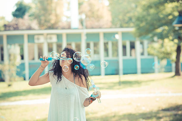 istock young beautiful moroccan curly woman blowing bubbles 520642067