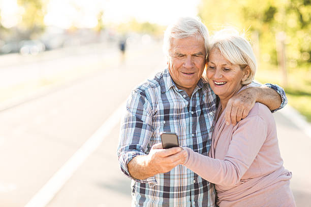 istock Smiling senior couple using mobile phone 520642773