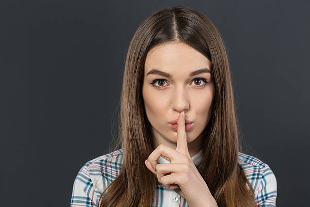 istock Nice girl holding her finger on the mouth 520646710