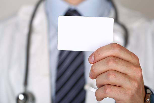 Male medicine doctor hand holding blank calling card Male medicine doctor hand holding blank calling card. Physician showing white visiting card in camera closeup. Contact information exchange concept. Introducing gesture at formal meeting telephone card stock pictures, royalty-free photos & images