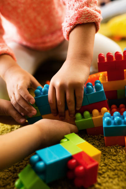istock Close-up of creative kids playing with plastic blocks. 520648764