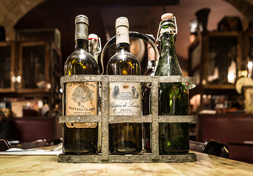 Bordeaux, France - March 24, 2016. Antiques french wine bottles from Bordeaux in a vintage metal bottle carrier. Aquitaine.
