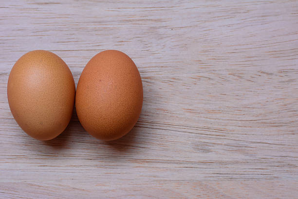 istock Fresh eggs on wooden background 520650438